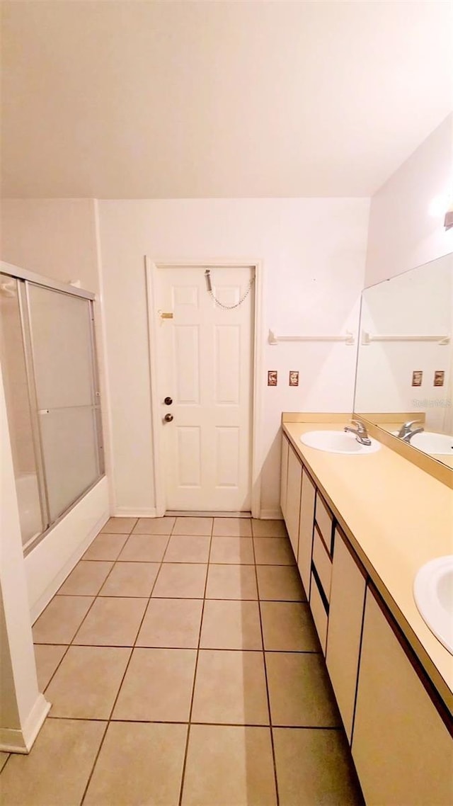 bathroom with double vanity, a sink, and tile patterned floors