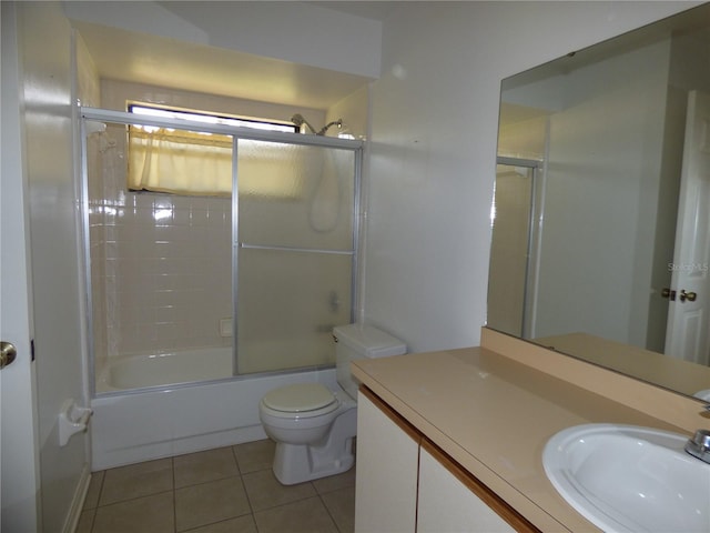 bathroom featuring bath / shower combo with glass door, vanity, toilet, and tile patterned floors