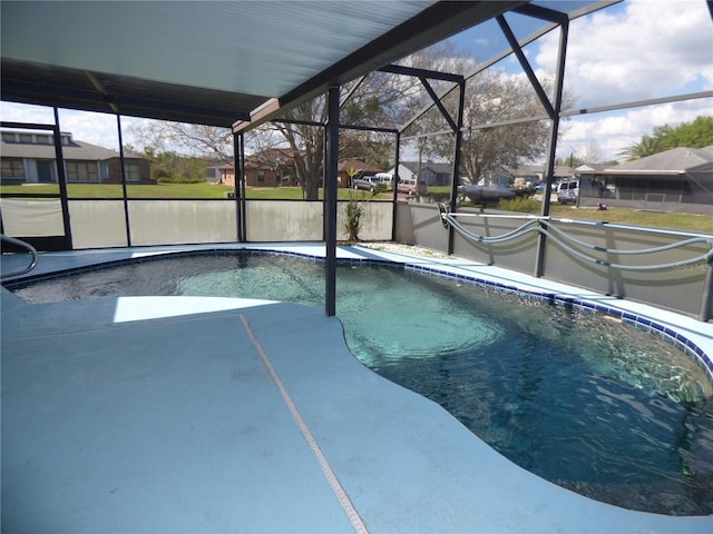 outdoor pool with glass enclosure and a patio area