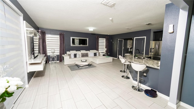 interior space featuring visible vents, baseboards, and a textured ceiling