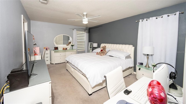 bedroom with light carpet, a textured ceiling, and a ceiling fan