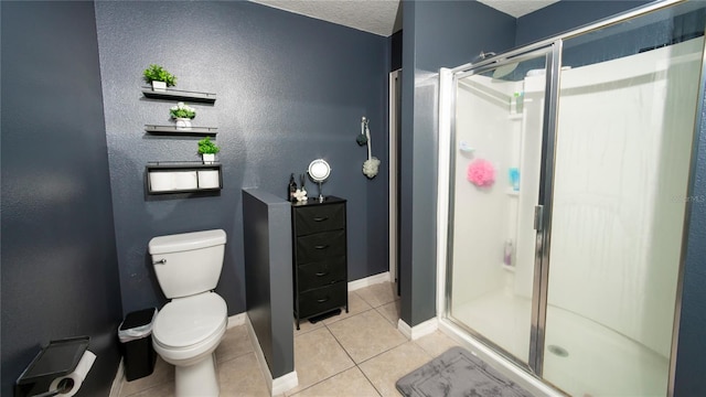 bathroom with baseboards, a stall shower, tile patterned flooring, a textured ceiling, and toilet