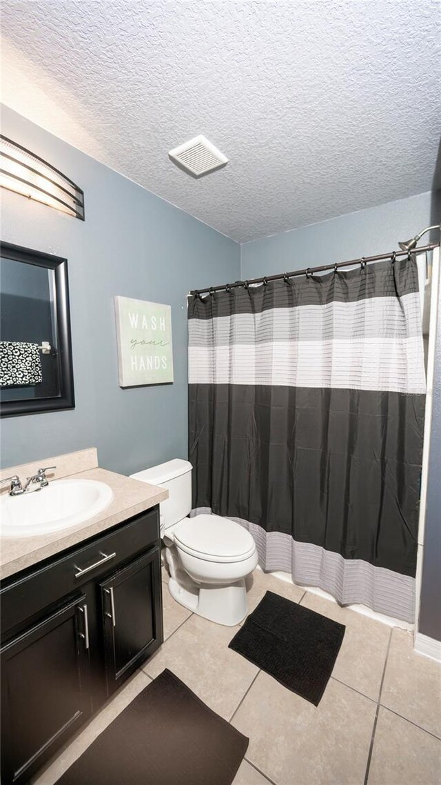 full bath featuring tile patterned flooring, visible vents, toilet, and vanity