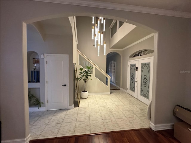 entryway featuring ornamental molding, wood finished floors, french doors, stairway, and baseboards