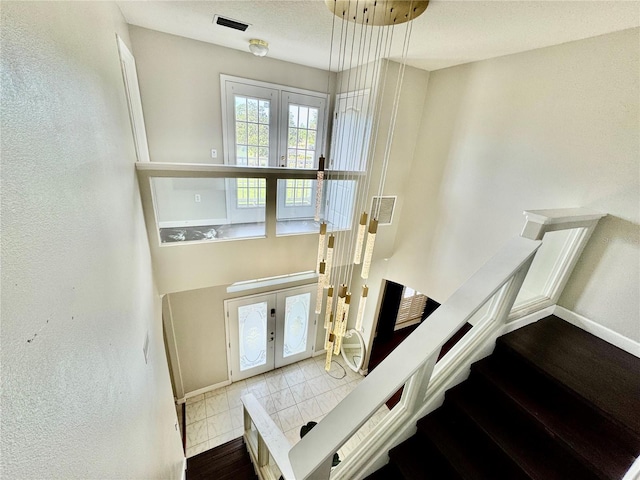 staircase with visible vents, french doors, and baseboards