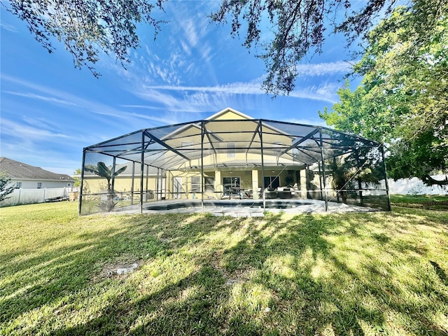 back of property with fence, a yard, an outdoor pool, a lanai, and a patio area