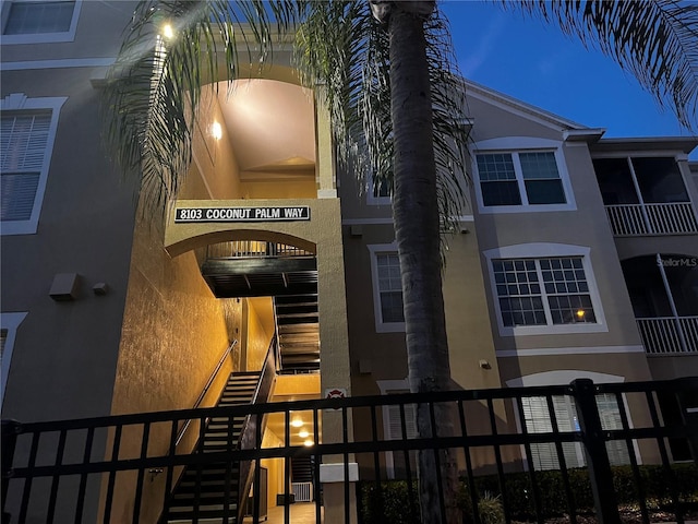 view of building exterior featuring stairs and fence