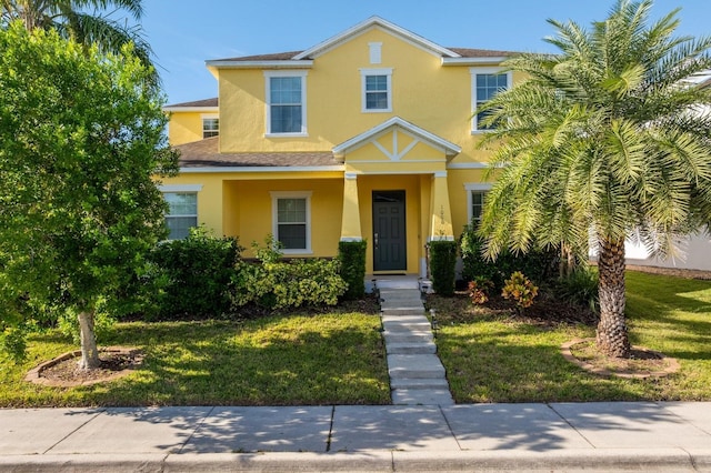 view of front of home featuring a front yard and stucco siding