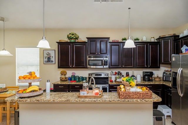 1000 Seburn Rd, Apopka, FL 32703 - kitchen with appliances with stainless steel finishes, light stone countertops, and hanging light fixtures