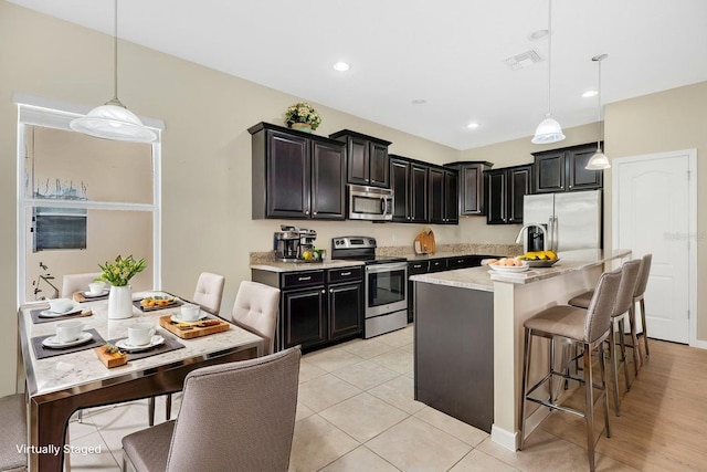 1000 Seburn Rd, Apopka, FL 32703 - kitchen with appliances with stainless steel finishes, a breakfast bar area, pendant lighting, a center island, and recessed lighting