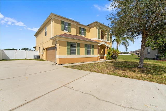 view of front of property featuring central air condition unit, fence, concrete driveway, stucco siding, and a front lawn