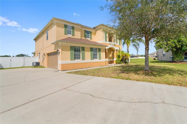 view of front of home with stucco siding, concrete driveway, a front yard, fence, and cooling unit