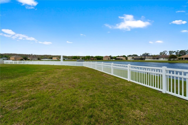 view of yard with a water view and fence