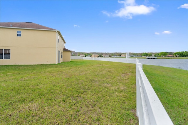 view of yard featuring a water view and fence