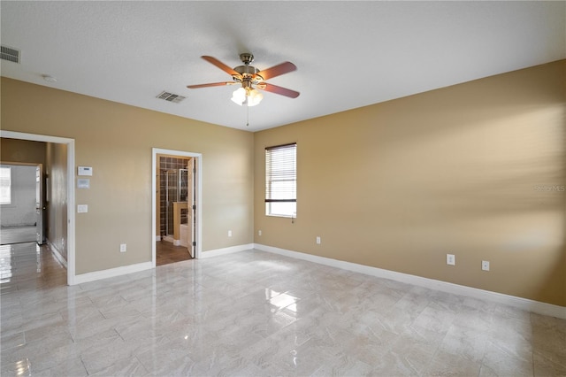 unfurnished bedroom featuring marble finish floor, visible vents, connected bathroom, and baseboards