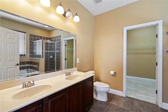 bathroom with a sink, a shower stall, toilet, and a spacious closet