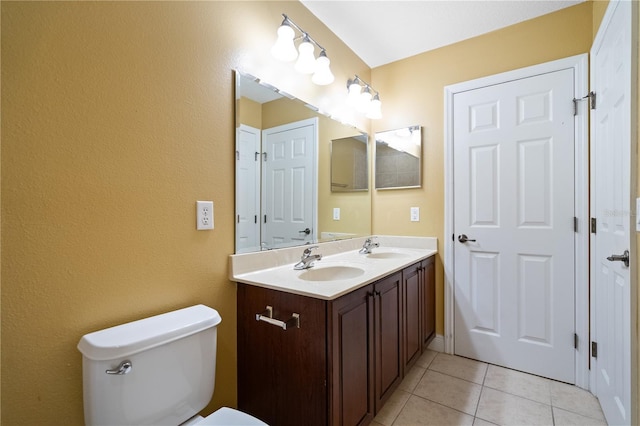 bathroom featuring tile patterned flooring, a sink, toilet, and double vanity