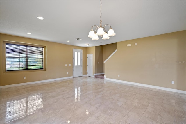 empty room with a notable chandelier, recessed lighting, and baseboards