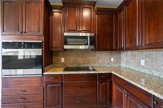 kitchen with light stone countertops, stainless steel appliances, and backsplash