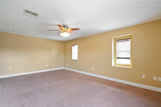 unfurnished room featuring ceiling fan, carpet floors, visible vents, and baseboards