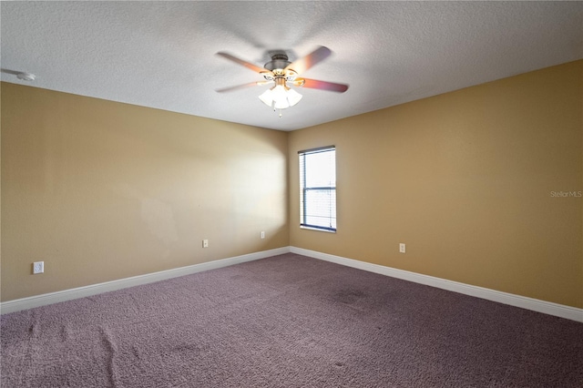 spare room with dark colored carpet, ceiling fan, a textured ceiling, and baseboards