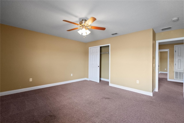 unfurnished bedroom with baseboards, visible vents, and dark colored carpet