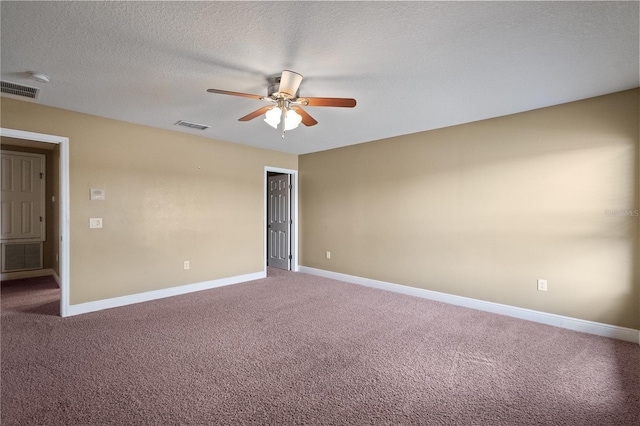 empty room featuring light colored carpet, visible vents, a textured ceiling, and baseboards