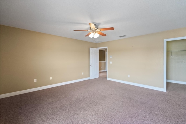 carpeted empty room featuring ceiling fan, a textured ceiling, visible vents, and baseboards