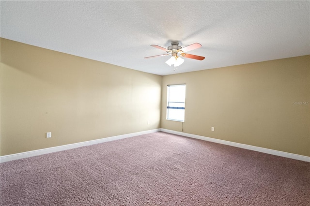 spare room featuring carpet floors, ceiling fan, baseboards, and a textured ceiling