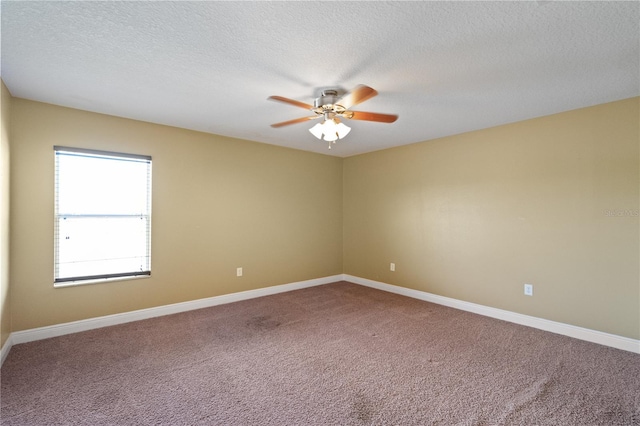 unfurnished room featuring carpet floors, ceiling fan, baseboards, and a textured ceiling