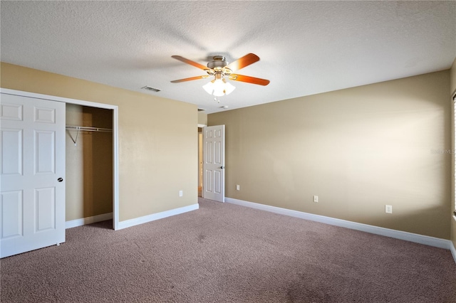 unfurnished bedroom with carpet floors, a closet, visible vents, a textured ceiling, and baseboards