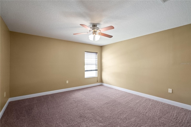 carpeted spare room with a textured ceiling, baseboards, and a ceiling fan