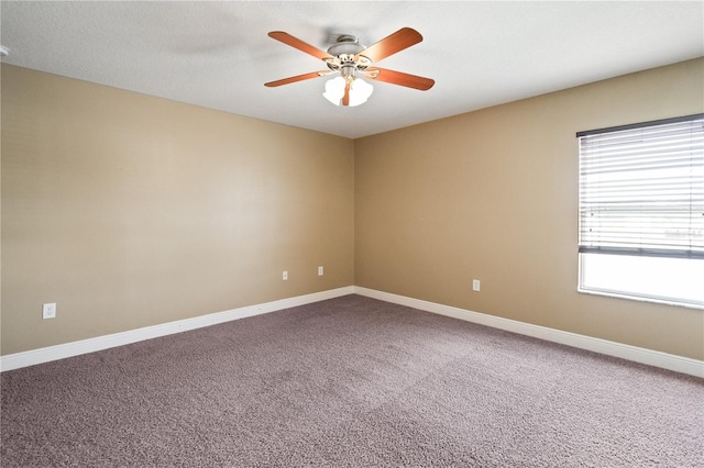 spare room with carpet floors, baseboards, and a ceiling fan