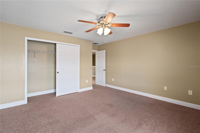 unfurnished bedroom with baseboards, visible vents, a ceiling fan, carpet flooring, and a closet