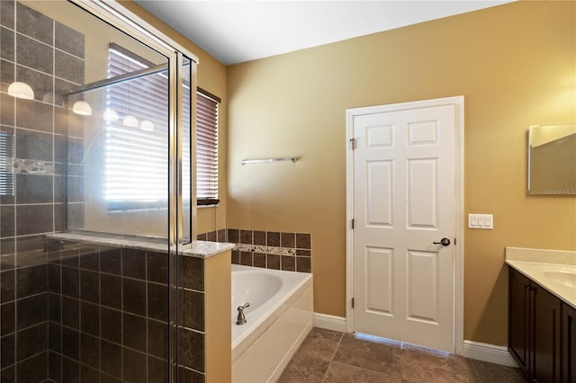 full bathroom featuring baseboards, a shower stall, vanity, and a bath