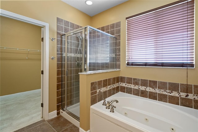 full bath with a shower stall, a tub with jets, a walk in closet, and tile patterned floors