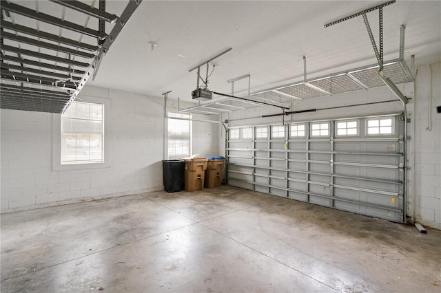 garage featuring concrete block wall and a garage door opener