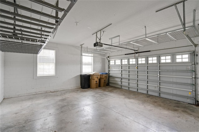 garage with concrete block wall and a garage door opener