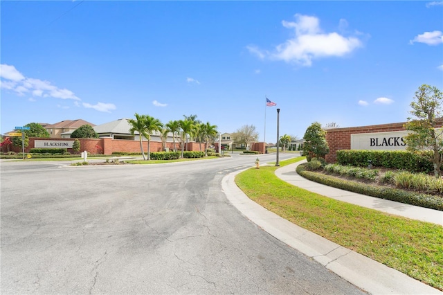 view of road with sidewalks, street lighting, a residential view, and curbs