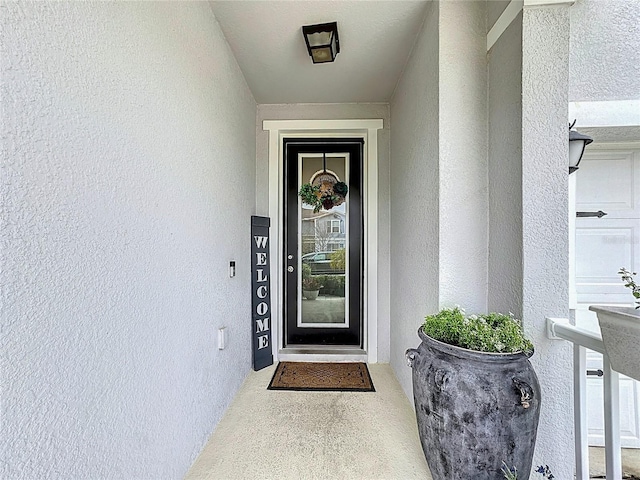 entrance to property featuring stucco siding