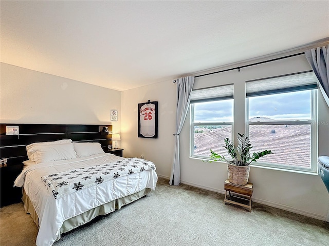 bedroom with light carpet and baseboards