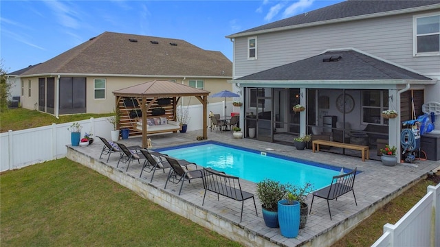 view of pool featuring a sunroom, a fenced backyard, and a gazebo