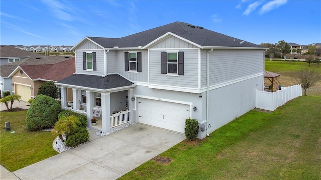 view of front of house featuring a porch, concrete driveway, board and batten siding, a front yard, and fence