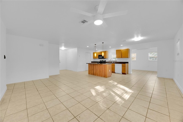 kitchen featuring visible vents, dishwasher, dark countertops, open floor plan, and a center island