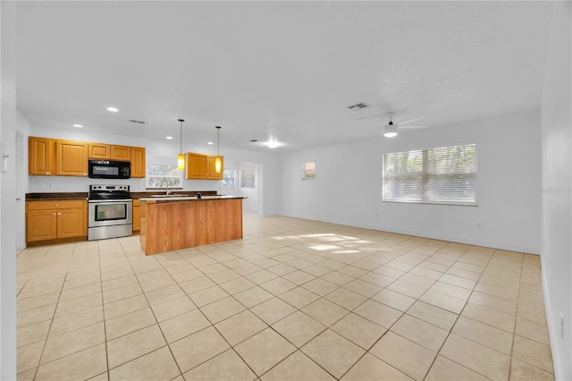 kitchen with black microwave, stainless steel electric stove, visible vents, open floor plan, and a center island