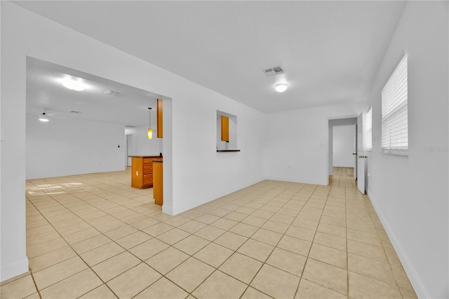 empty room with baseboards, visible vents, and light tile patterned flooring