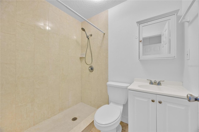 full bath with toilet, a textured ceiling, tiled shower, and vanity