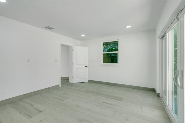 spare room featuring light wood-style flooring, visible vents, baseboards, and recessed lighting