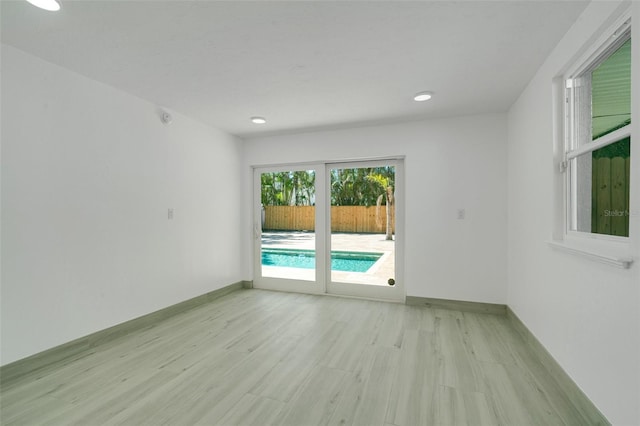 empty room with light wood-style flooring and baseboards