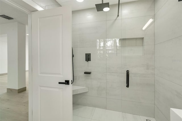 bathroom featuring a shower stall, visible vents, and tile walls